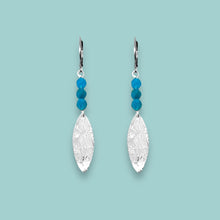 Charger l&#39;image dans la galerie, Boucles d&#39;oreilles fines en pointe en métal martelé doré à l&#39;or fin et petites perles d&#39;apatite bleue, sur fond vert pastel
