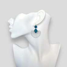 Charger l&#39;image dans la galerie, Grandes boucles d&#39;oreilles argentées en forme d&#39;éventail style art déco, avec empiècements de cuir vert canard, portées à l&#39;oreille sur un buste blanc
