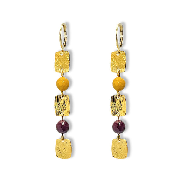 Fines boucles d'oreilles pendantes en chapelet de petits sequins rectangulaires en métal martelé doré à l'or fin et perles de mokaite ocre et lie de vin, sur fond blanc