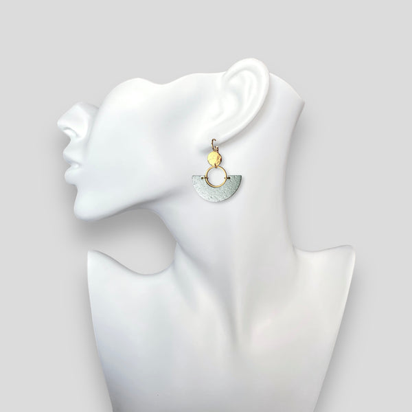 boucle d'oreille dorée en forme de demi-lune en liège argenté, portée à l'oreille