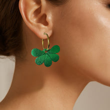 Charger l&#39;image dans la galerie, Boucles d&#39;oreilles créoles dorées avec pendentifs en cuir vert métallisé en forme de fleurs, portées à l&#39;oreille
