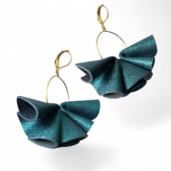 Grandes boucles d'oreilles dorées aériennes et sculpturales en cuir plissé bleu paon pailleté, sur fond blanc