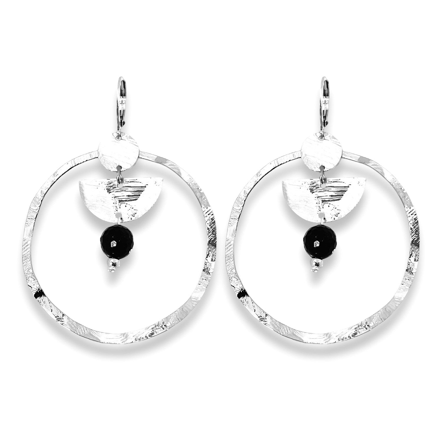 Grandes boucles d'oreilles créoles en métal martelé argenté et pierres naturelles de tourmaline noire accrochée à une demi-lune, sur fond blanc