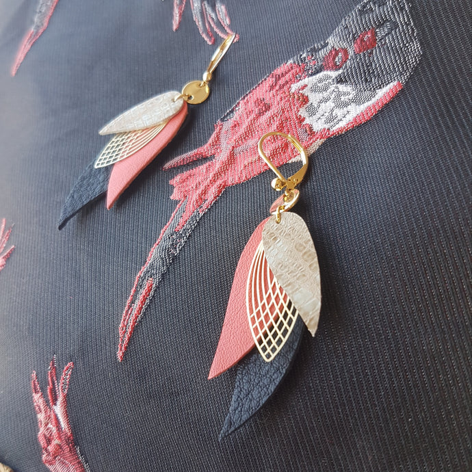 boucles d'oreilles dorées Nune modèle Ara en plumes de cuirs gris façon serpent, rose saumon et noir grainé sur fond noir