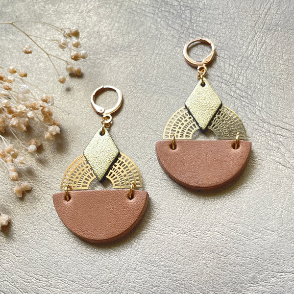 Boucles d'oreilles dorées Nune modèle Echo en cuirs beige amande et doré satiné sur fond gris doré, vues de face