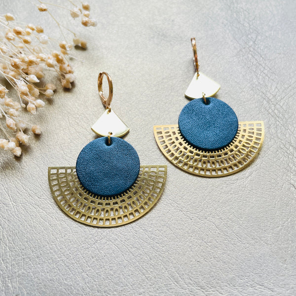 Boucles d'oreilles dorées Nune modèle Ephésia en cuir bleu nuit métallisé sur fond gris doré