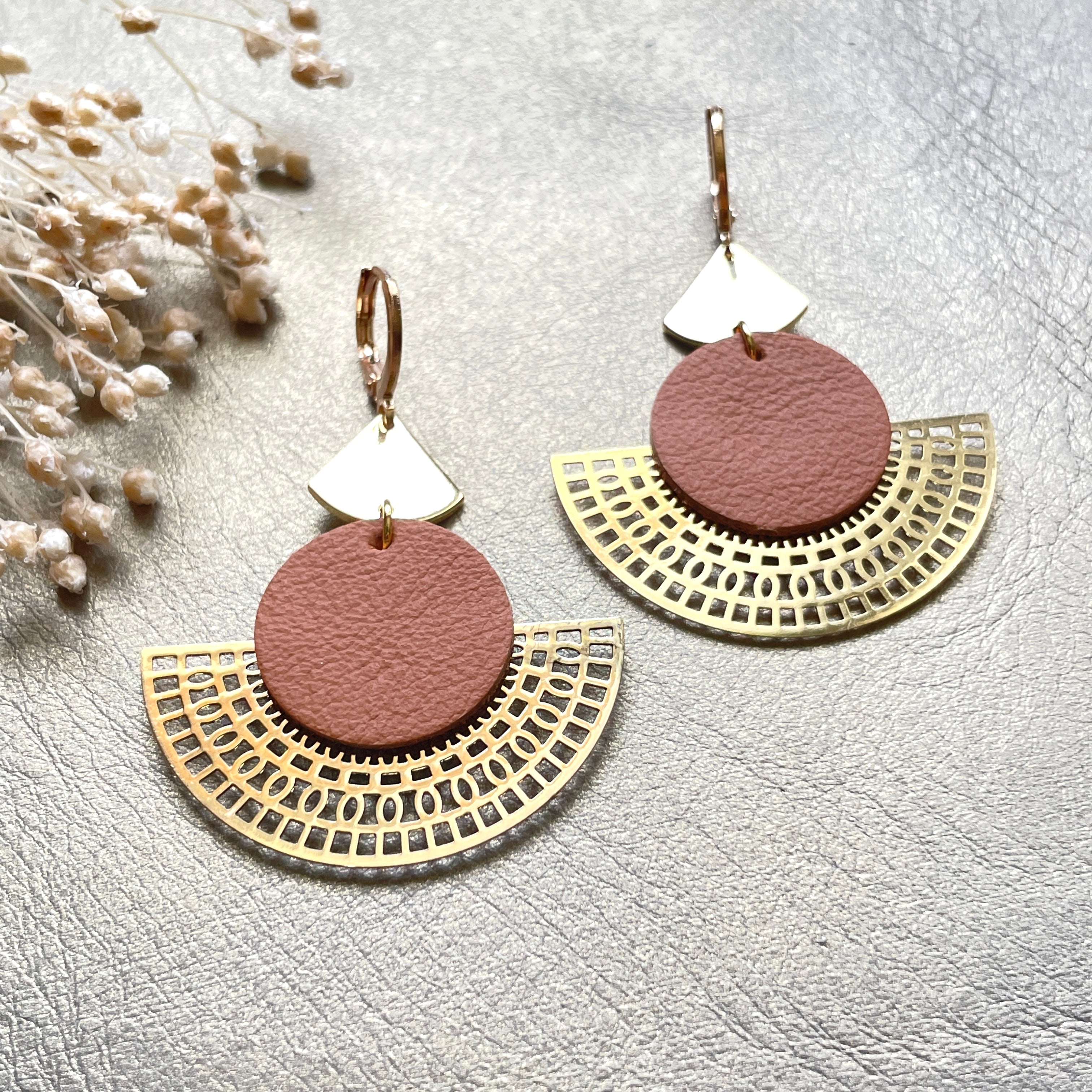 Boucles d'oreilles dorées Nune modèle Ephésia en cuir camel sur fond gris doré