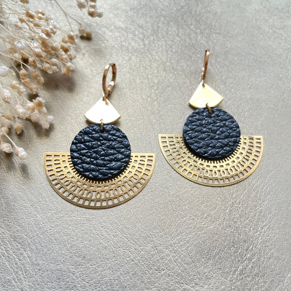 Boucles d'oreilles dorées Nune modèle Ephésia en cuir noir grainé sur fond gris doré