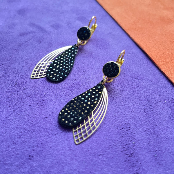 Boucles d'oreilles dorées Nune modèle Pétales en cuir noir grainé irisé sur fond de cuir violet et orange velours