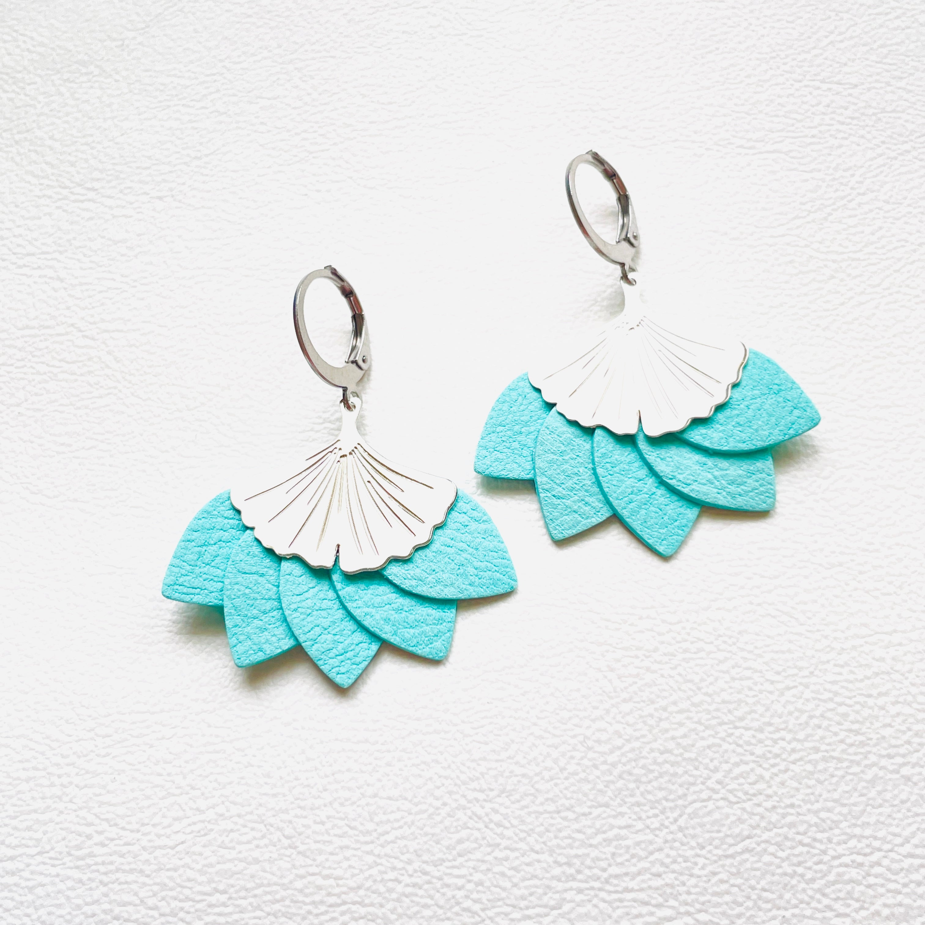 Boucles d'oreilles argentées Nune modèle Ginka en pétales de cuir vert menthe, sur fond blanc
