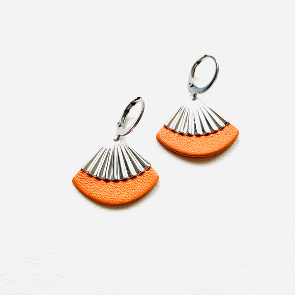 Petites boucles d'oreilles argentées Nune modèle Alya en forme d'éventail en cuir orange, sur fond cuir blanc