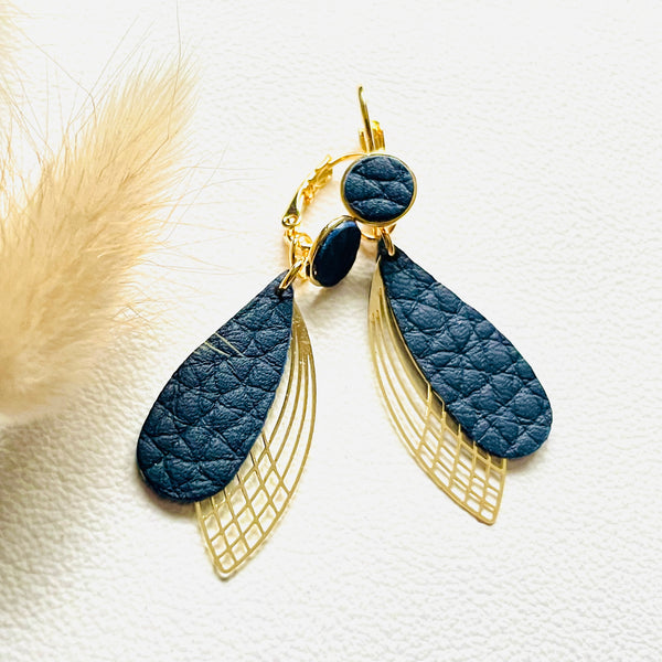 Boucles d'oreilles dorées Nune modèle Pétales en cuir noir grainé sur fond blanc