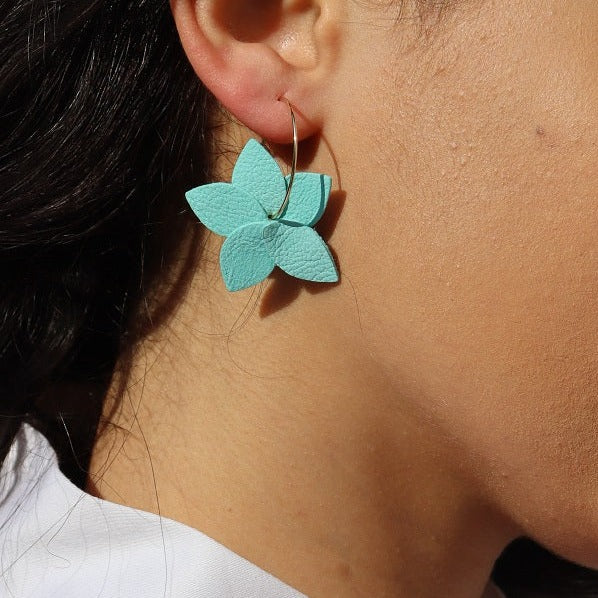 Nune petite créole Jasmin en cuir vert menthe satiné recyclé et anneaux dorés, portée à l'oreille