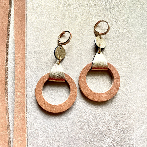 boucles d'oreilles dorées Nune modèle Cyllène en cuirs beige amande et doré satiné sur fond gris