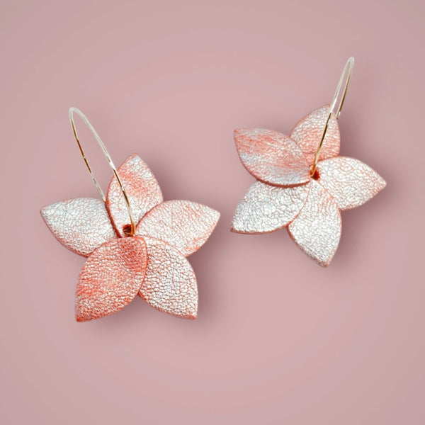 Nune petites créoles Jasmin Argenté en forme de fleurs en cuir rose nacré et anneaux en acier inoxydable argenté, sur fond vieux rose