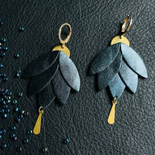 Charger l&#39;image dans la galerie, Boucles d&#39;oreilles Nune modèle Nymphéa en cuir bleu nuit métallisé, laiton brut et attaché dorées à l&#39;or fin, sur fond de cuir noir grainé et perles de rocaille
