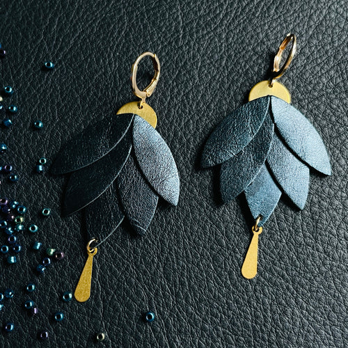 Boucles d'oreilles Nune modèle Nymphéa en cuir bleu nuit métallisé, laiton brut et attaché dorées à l'or fin, sur fond de cuir noir grainé et perles de rocaille