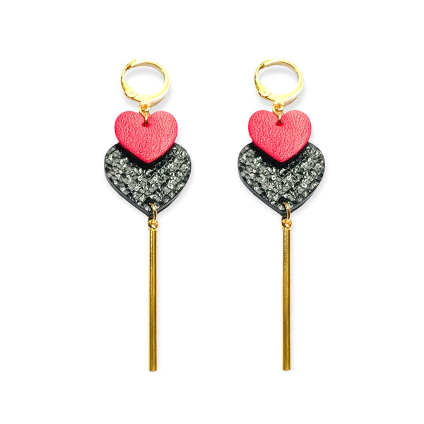 NUNE Longues boucles d'oreilles dorées modèle Félicie avec 2 cœurs imbriqués en cuirs recyclés rose fuschia et noir brillant façon lézard, sur fond blanc