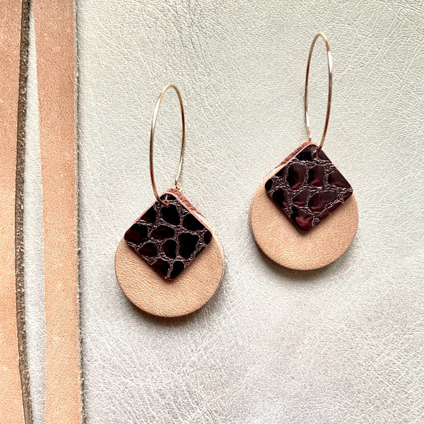 boucles d'oreilles dorées Nune modèle Héra en cuirs beige amande et chocolat brillant façon croco sur fond gris doré