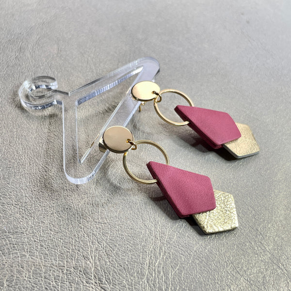 NUNE puces d'oreilles dorées Sagittis, pendentifs en duo de losanges en cuir recyclé vieux rose et doré, sur fond beige doré