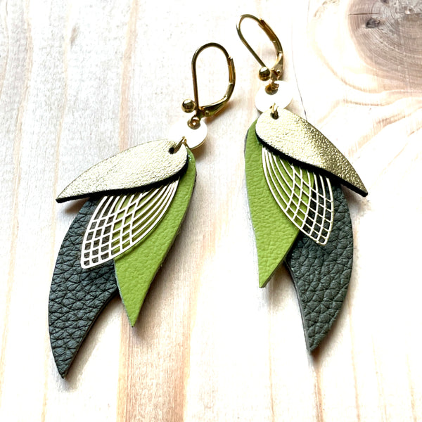 boucles d'oreilles dorées Nune modèle Ara en plumes de cuirs doré satiné, vert olive et kaki grainé sur bois clair