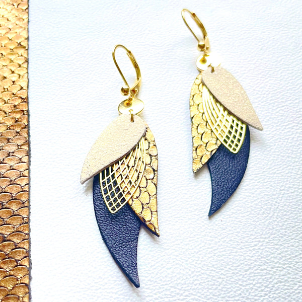 boucles d'oreilles dorées Nune modèle Ara en plumes de cuir gris nacré, bronze écaille patiné et noir grainé sur fond blanc