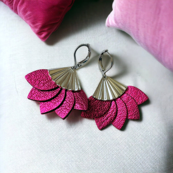 Boucles d'oreilles argentées Nune modèle Sakura en pétales de cuir fushia métallisé, sur fond blanc avec coussins roses