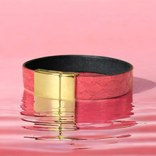 Charger l&#39;image dans la galerie, bracelet en cuir marin rose saumon avec fermoir doré aimanté, posé sur de l&#39;eau rose

