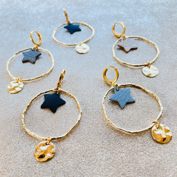 Boucles d'oreilles Nune modèle Naleli dorées à l'or fin de forme créole avec étoile de cuir coloré, sur fond cuir beige pailleté