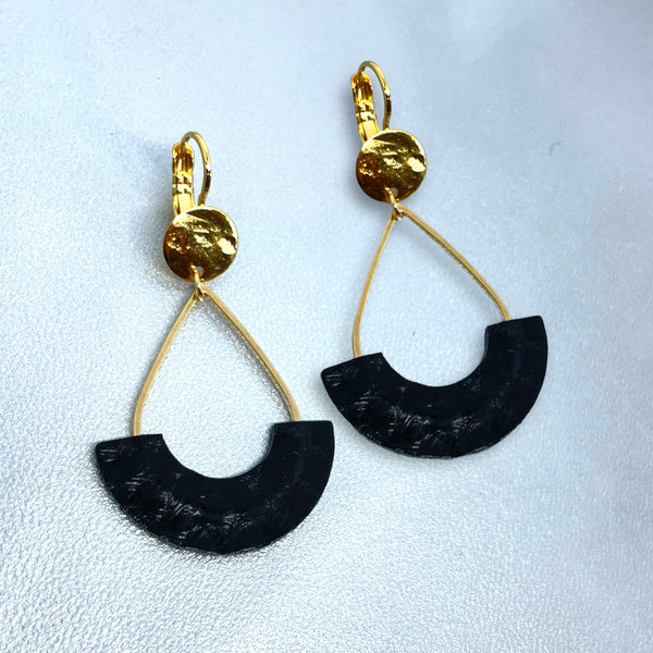 Boucles d'oreilles Anoush de Nune, dorées à l'or fin avec cuir marin, cuir de poisson saumon noir d'encre, en forme de demi-lune, sur fond cuir gris argenté