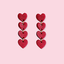 Charger l&#39;image dans la galerie, Puces d&#39;oreilles Tamaya, chapelets de petits cœurs en cuir rubis métallisé recyclé sur fond rose pastel
