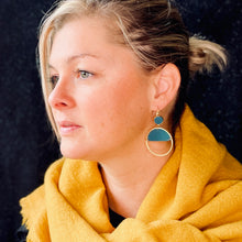 Charger l&#39;image dans la galerie, Boucle d&#39;oreille créole dorée Nune modèle Lua avec cuir vert canard, portée par un modèle aux cheveux blonds
