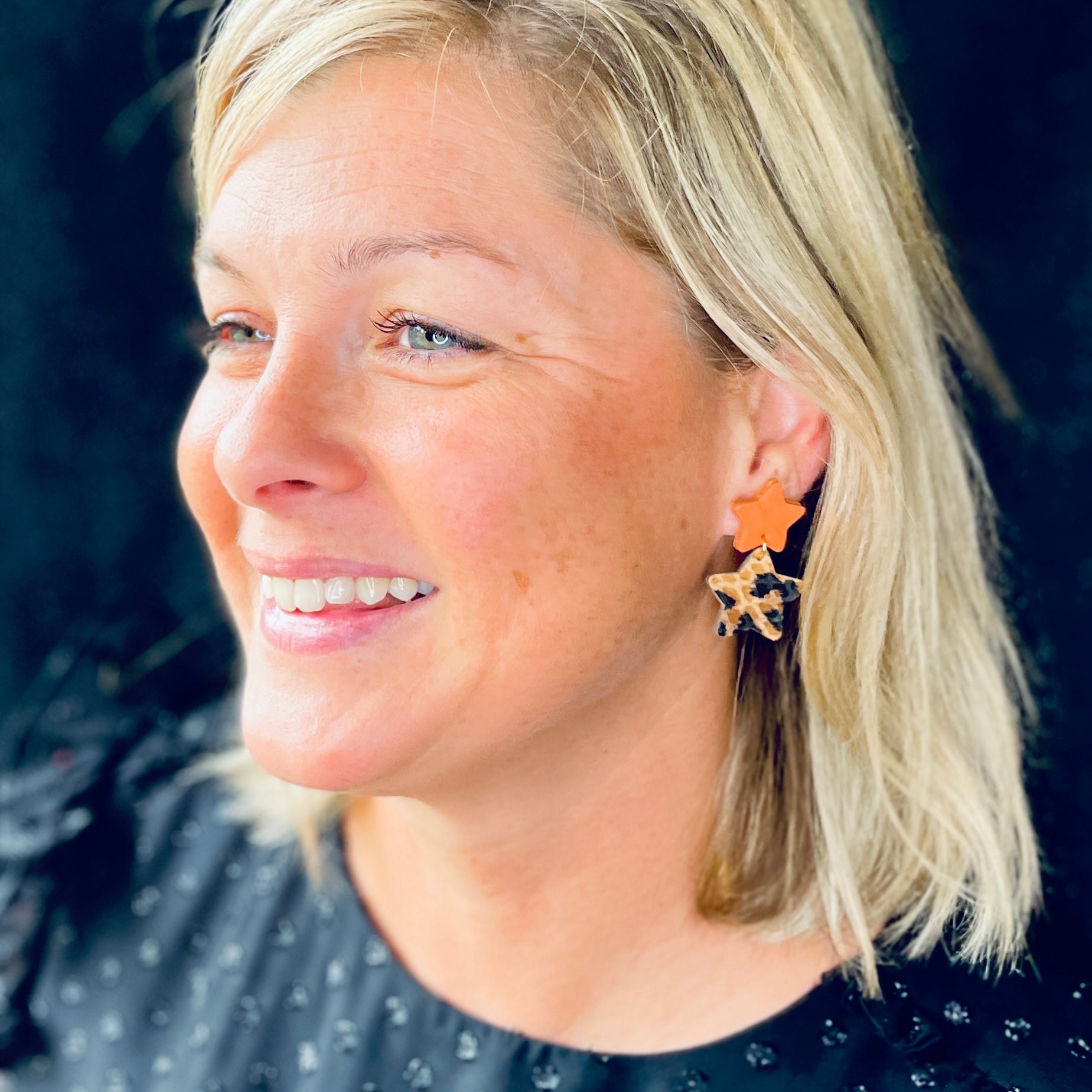 Nune puce d'oreilles Starlette, en forme d'étoiles tout cuir, corail rosé et léopard, portée à l'oreille