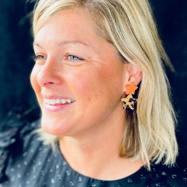 Nune puce d'oreilles Starlette, en forme d'étoiles tout cuir, corail rosé et léopard, portée à l'oreille