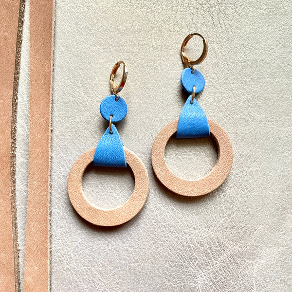 boucles d'oreilles dorées Nune modèle Cyllène en cuirs beige amande et bleu denim mat sur fond gris