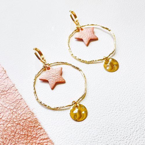 Boucles d'oreilles Nune modèle Naleli dorées à l'or fin de forme créole avec étoile de cuir corail nacré clair, sur fond cuir blanc