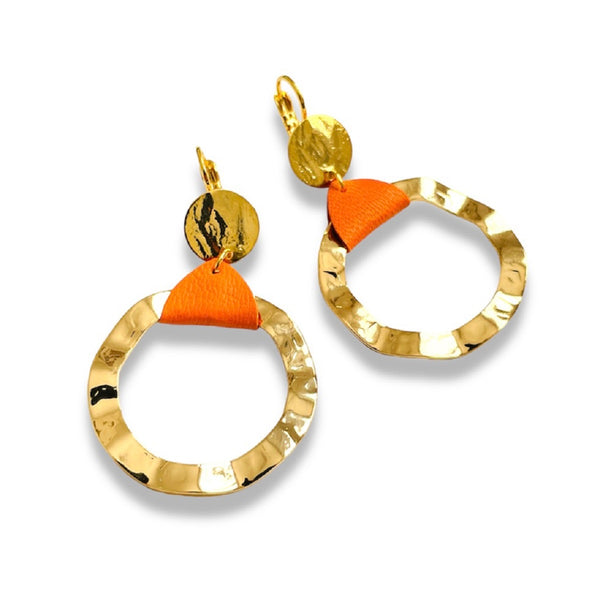 Boucles d'oreilles créoles dorées Nune modèle Cael en cuir orange sur fond blanc