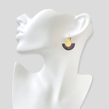Charger l&#39;image dans la galerie, NUNE boucle d&#39;oreille dorée en forme de demi-lune en cuir noir pailleté irisé et or recyclé, portée à l&#39;oreille. Modèle Téthys
