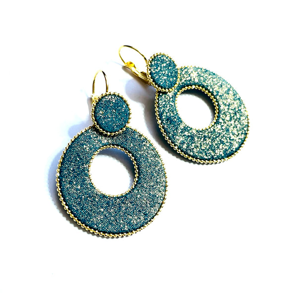 boucles d'oreilles créoles Nune modèle Céleste en forme de cercles en cuir vert canard pailleté or, cerclées de chaîne dorée, sur fond blanc