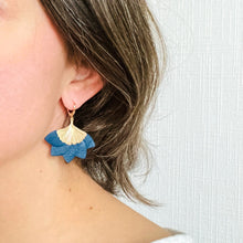 Charger l&#39;image dans la galerie, Boucle d&#39;oreille dorée Nune modèle Ginka en cuir bleu marine satiné portée à l&#39;oreille par une jeune femme
