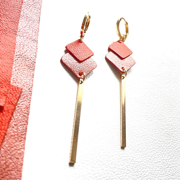 boucles d'oreilles dorées Nune modèle Ada avec duo de losanges en cuirs orange satiné et corail nacré et longue tige fine dorée sur fond blanc
