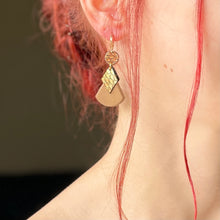 Charger l&#39;image dans la galerie, boucle d&#39;oreille dorée Nune modèle Thémis en cuirs beige amande et doré façon croco portée par un modèle aux cheveux rouges et au teint pâle
