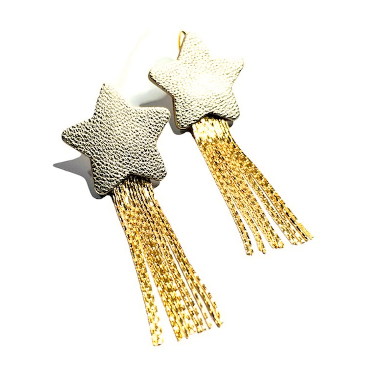 Nune Boucles d'oreilles légères SuperStella, grandes étoiles en cuir argenté recyclé et leurs longues et fines chaînettes dorées, sur fond blanc vues de dessus