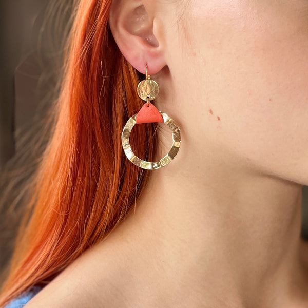 Boucle d'oreille créole dorée Nune modèle Cael en cuir orange portée par un modèle aux cheveux roux