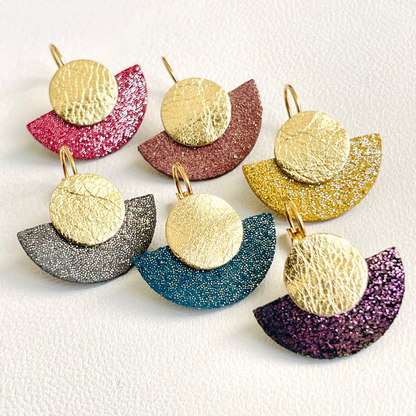 NUNE 6 boucles d'oreilles dorées en forme de demi-lune en 6 teintes de cuirs pailletés et or recyclés, sur fond blanc. Modèle Téthys