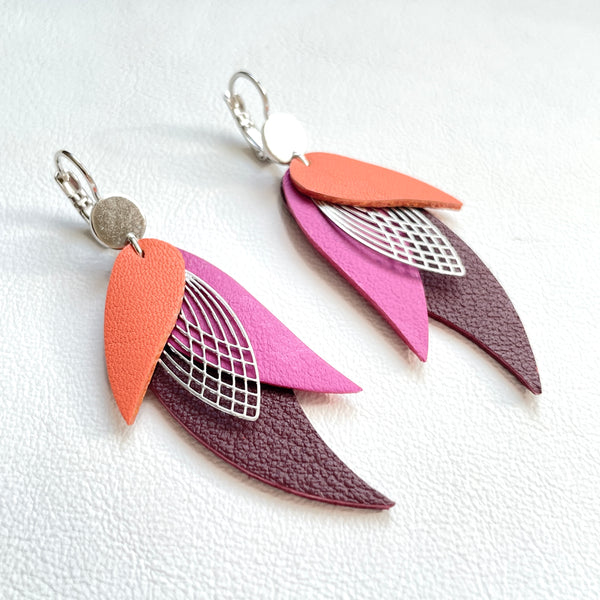 Boucles d'oreilles argentées Nune en forme de plumes, modèle Ara en cuirs saumon clair, mauve et grenat grainé sur fond cuir blanc