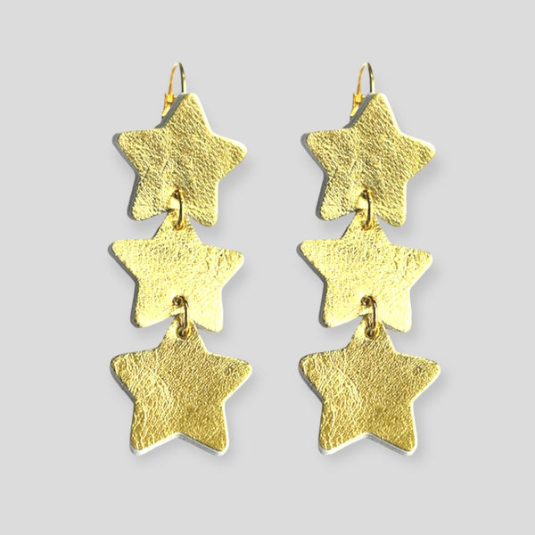 NUNE Boucles d'oreilles Starlight, chapelet d'étoiles en cuir recyclé doré, sur fond gris vues de face