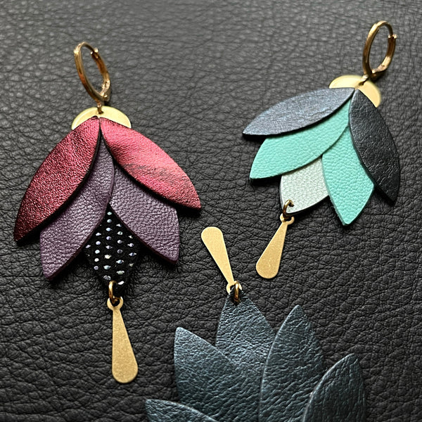 Boucles d'oreilles dorées pendantes Nune modèle Nymphéa en cuirs recyclés, sur fond de cuir noir grainé et perles de rocaille