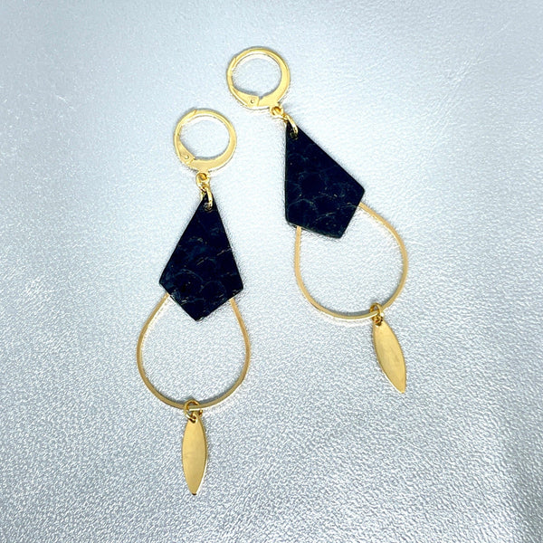 Boucles d'oreilles Gali de Nune, dorées à l'or fin avec triangle de cuir marin, cuir de poisson saumon noir d'encre, de forme grande goutte, sur fond cuir gris argenté