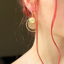 Charger l&#39;image dans la galerie, boucle d&#39;oreille dorée Nune modèle Danaé en cuirs beige amande et doré satiné portée par un modèle aux cheveux rouges et au teint pâle

